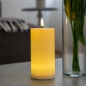 Crème LED candle glowing in a living room, lifelike flame
