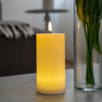 Vela LED Crème encendida en un salón, llama realista