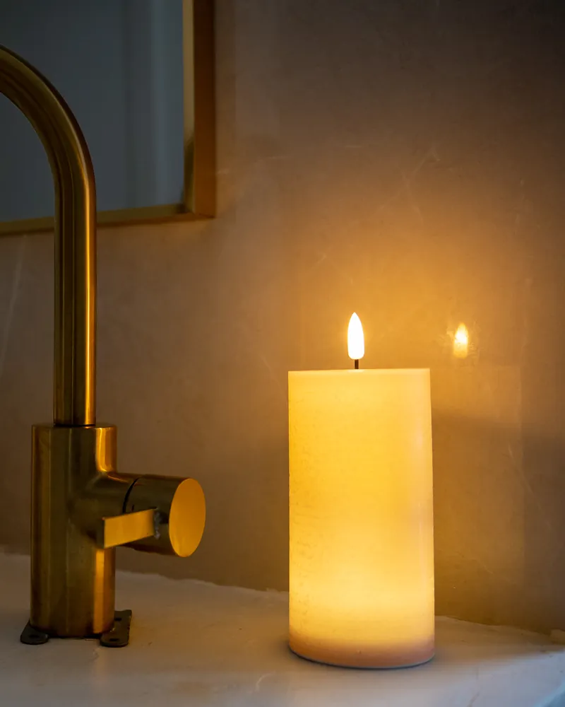 Bougie LED rechargeable près d'une vasque de salle de bain